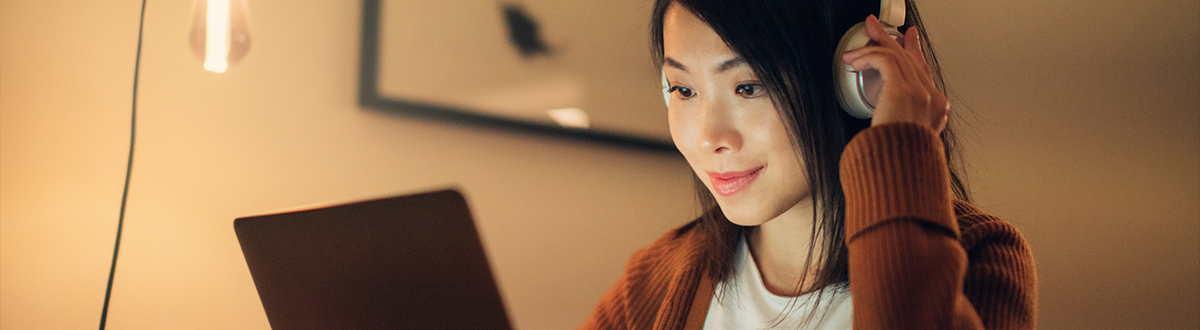 A Young women listening with headphones and looking at tablet